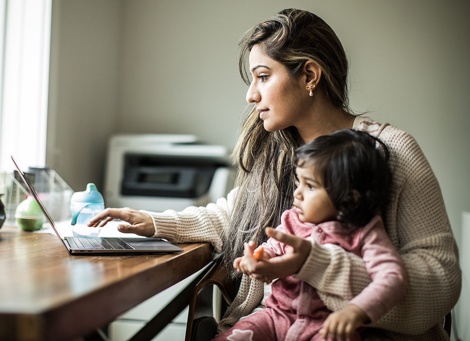 Mother working from home while caring for baby